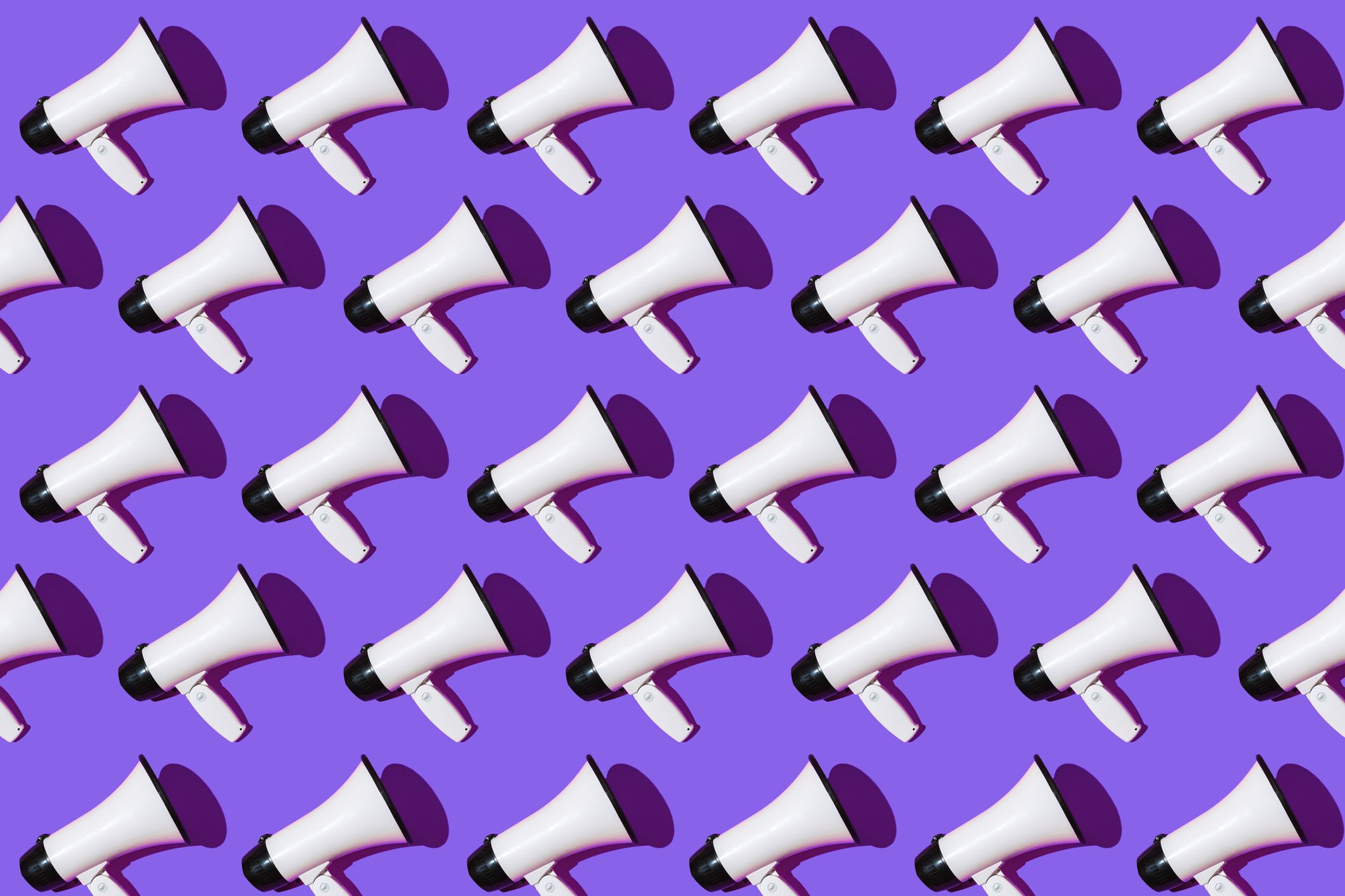 White megaphones pattern with black ornament on purple background. Shout, message, announcement and news concept.