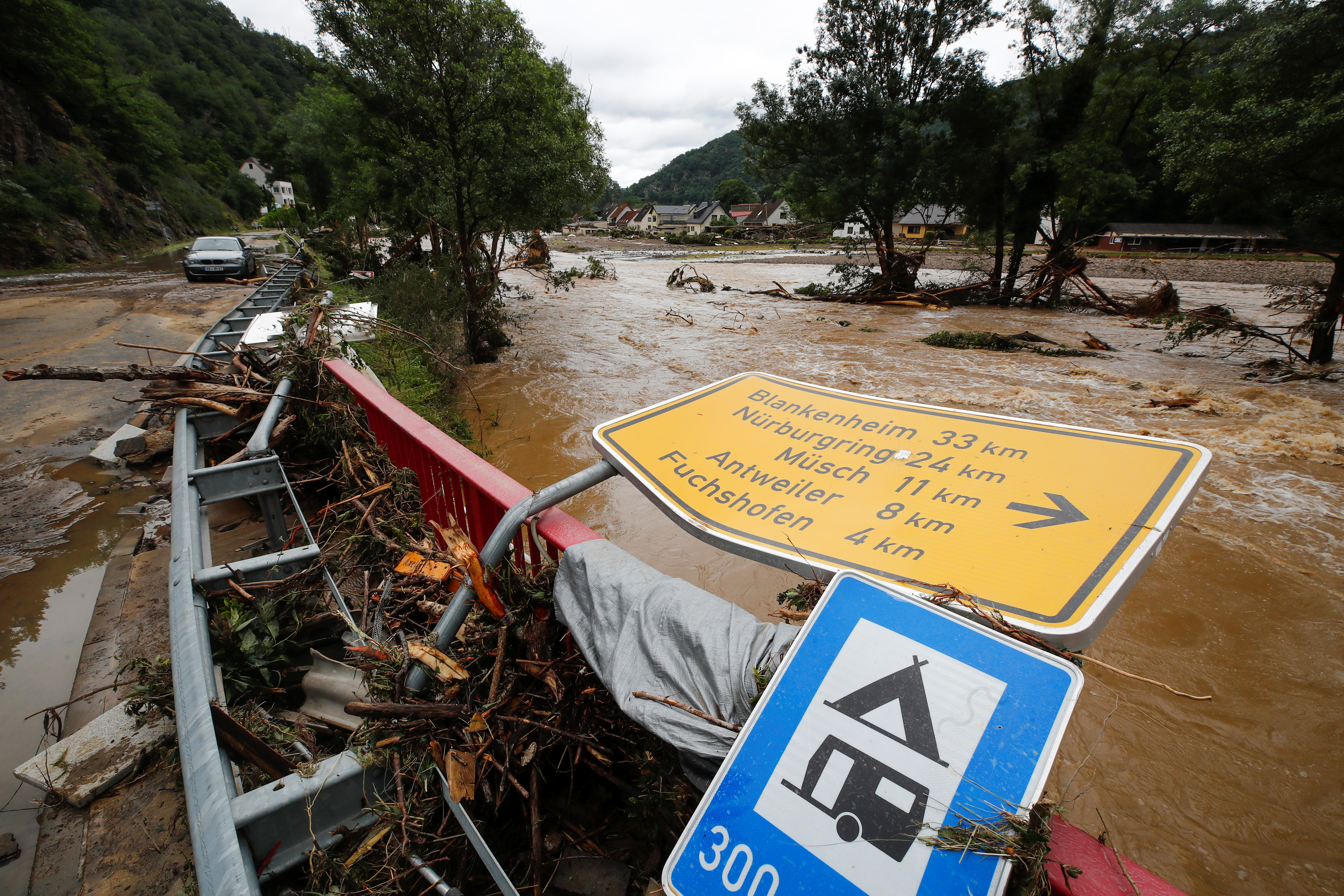 A collapsed sign is seen next to a river at a flood-affected area, following heavy rainfalls, in Schuld, Germany, July 15, 2021. REUTERS/Wolfgang Rattay
