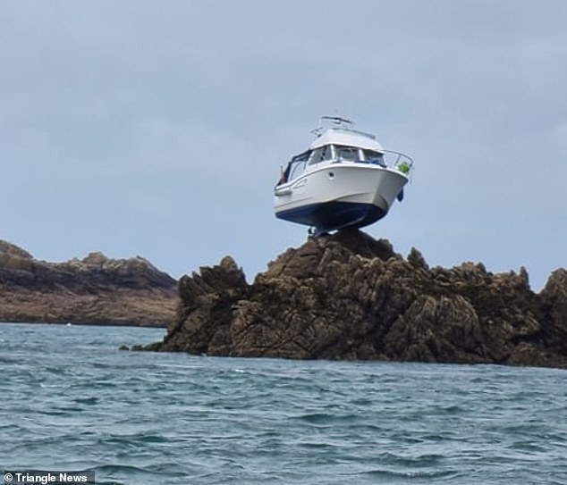 The motor cruiser became stranded on top of a rock 10ft in the air after colliding with an underwater reef