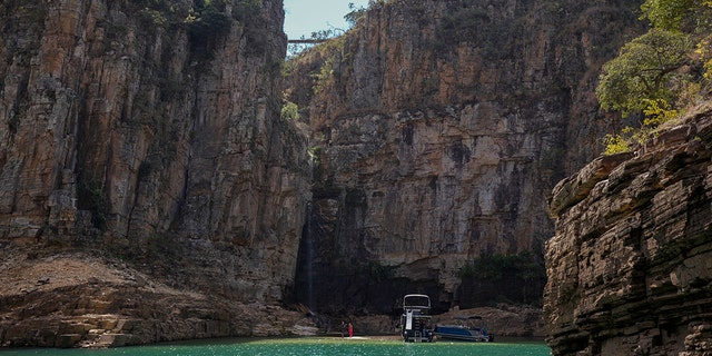 A tourist boat navigates through a canyon in Furnas Lake, near Capitolio City, Brazil, Sept. 2, 2021.