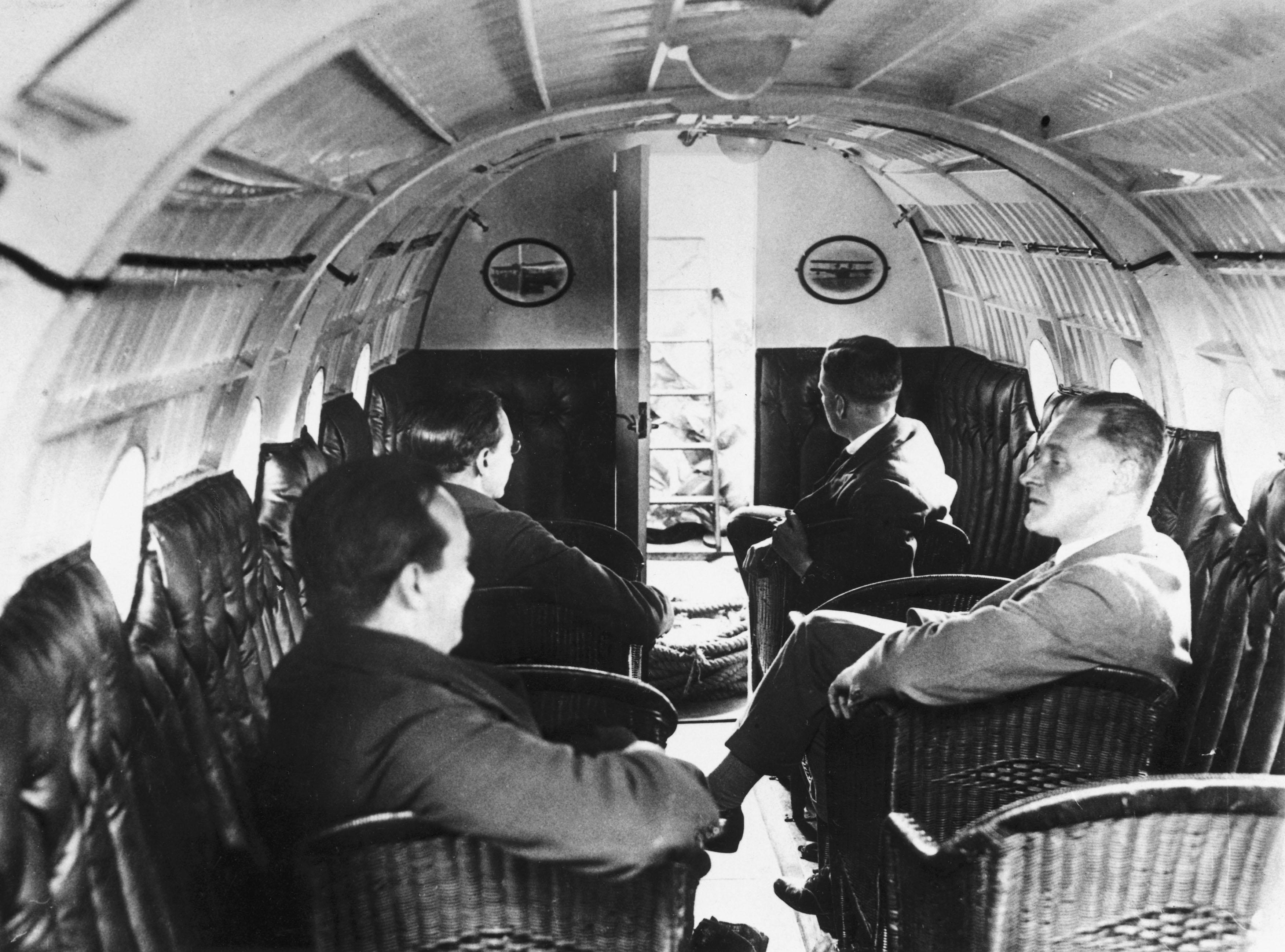 Passengers sit talking in the main cabin of a Supermarine Swan II