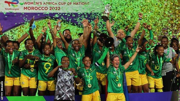 Andile Dlamini, Refiloe Jane and Janine van Wyk lift the Women's Africa Cup of Nations trophy for South Africa
