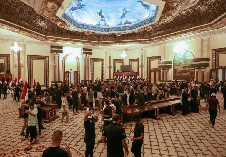 TOPSHOT - Supporters of Iraqi Shiite cleric Moqtada Sadr gather inside the Republican Palace in the capital Baghdad's Green Zone, on August 29, 2022. - Dozens of angry supporters of the powerful cleric stormed the Republican Palace, a ceremonial building in the fortified Green Zone, a security source said, shortly after Sadr said he was quitting politics. The army has announced a Baghdad-wide curfew to start from 3:30 pm (1230 GMT). (Photo by Ahmad Al-Rubaye / AFP) (Photo by AHMAD AL-RUBAYE/AFP via Getty Images)