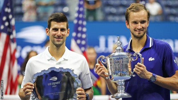 Novak Djokovic lifts his US Open runner-up trophy alongside champion Daniil Medvedev after the 2021 final in New York