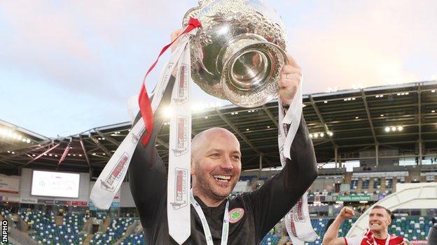 Cliftonville manager Paddy McLaughlin lifts the League Cup after the win over Coleraine in the final