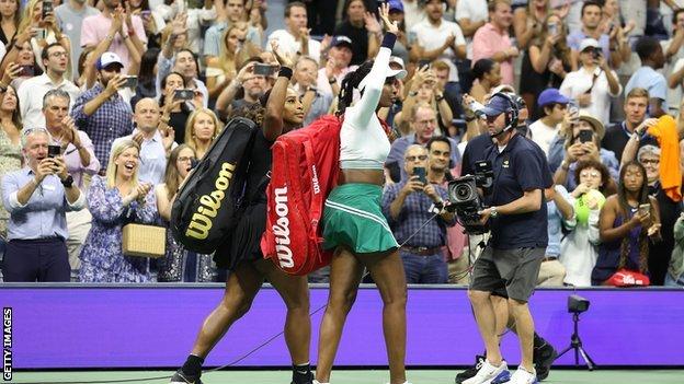 Serena and Venus Williams wave to the crowd as they leave Arthur Ashe Stadium