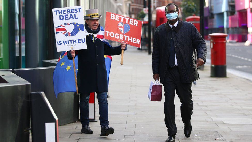 Who is Britain's new finance minister, Kwasi Kwarteng? Kwasi Kwarteng walks by Brexit protestor in London