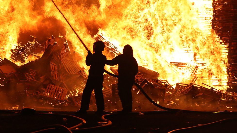 Firefighters extinguishing the huge bonfire in Cumbernauld