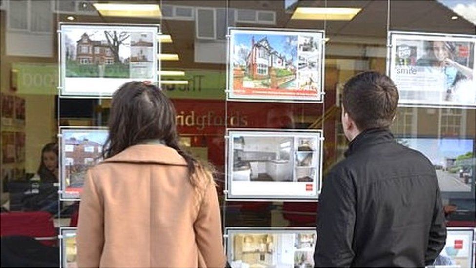 People looking in estate agents window