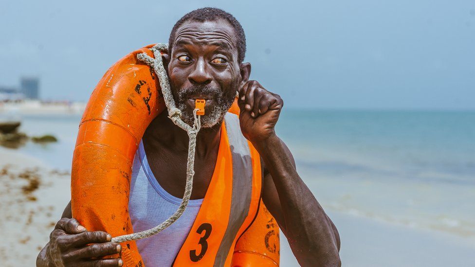 Lifeguard Nicholas Paul whistling on the beach in Lagos, Nigeria