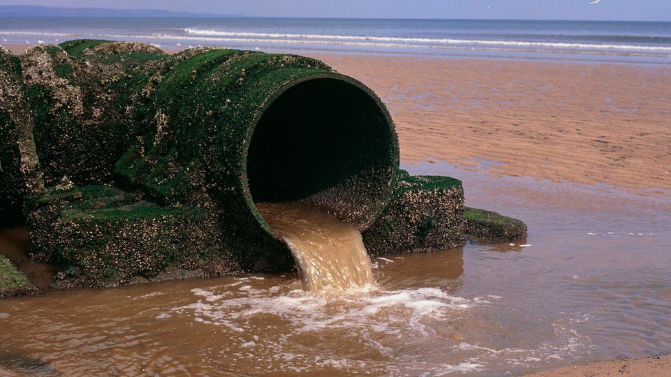 An outlet pipe discharging sewage onto a North sea beach at Hartlepool, Cleveland.