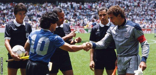 Argentina forward Diego Maradona (wearing 10), referee Ali Bin Nasser (centre) and England goalkeeper Peter Shilton (right)