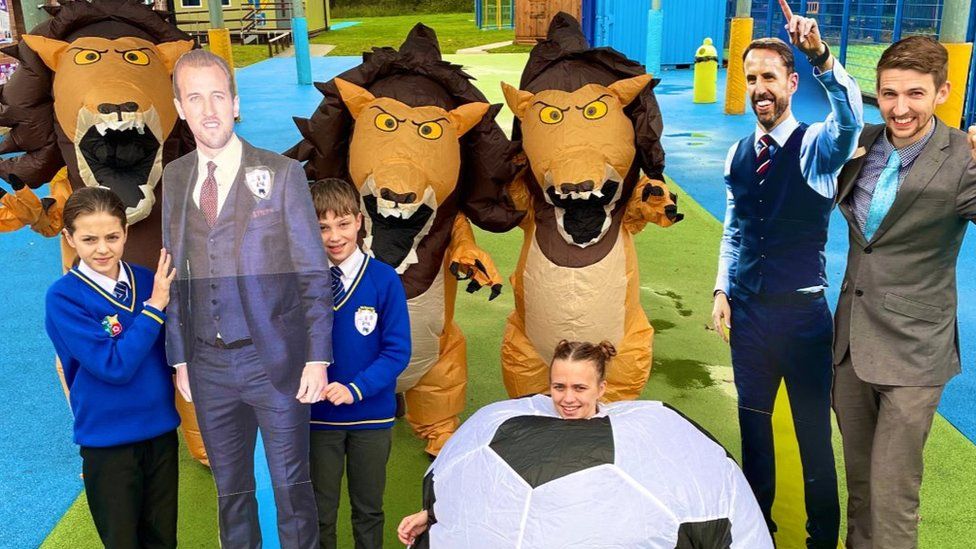 Pupils and teachers with cut-outs of footballers