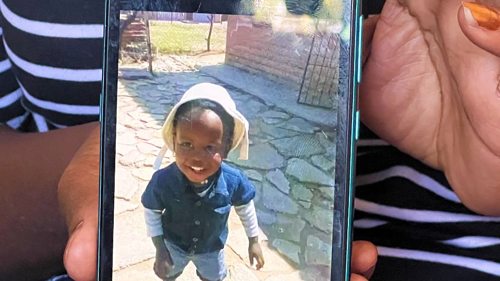 Keketso Saule's aunt shows a photo of her nephew on her mobile phone