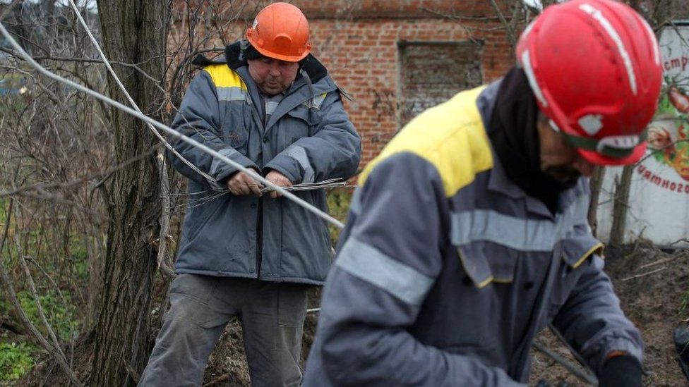 Workers repair broken power lines in Tatianovka village near Svyatohirs'k in Donetsk region on November 25,