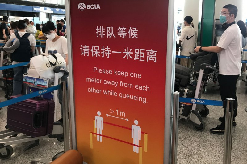 Passengers wear mandatory face masks while waiting in a massive queue to check in for their flights at Beijing international airport on August 18, 2021. Chinese passengers are facing restrictions in the United States and Italy after an increase in the virus's spread there. File Photo by Stephen Shaver/UPI | <a href="/News_Photos/lp/d834ed96eb2d9cd14b7c7cf512ccc850/" target="_blank">License Photo</a>
