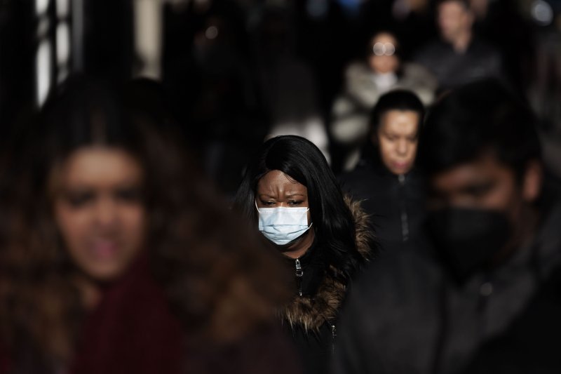 A woman wears a mask while walking on a street in New York on Dec. 14. Health officials in New York City recently began recommending that people wear masks in public indoor spaces as well as in crowded outdoor areas due to the large number of cases of COVID-19, as well as the seasonal flu and RSV, respiratory syncytial virus. File Photo by Justin Lane/EPA-EFE