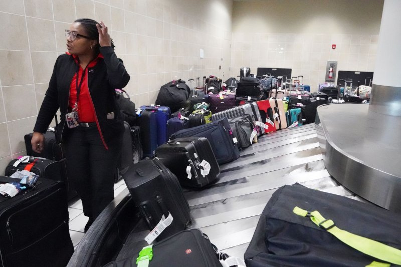 A Southwest Airlines baggage specialist makes her way through hundreds of suitcases in the Southwest Airlines baggage claim area at St. Louis-Lambert International Airport in St. Louis on Tuesday. Photo by Bill Greenblatt/UPI | <a href="/News_Photos/lp/3d5a0e98509cb64d474e2c4e782e5e7e/" target="_blank">License Photo</a>