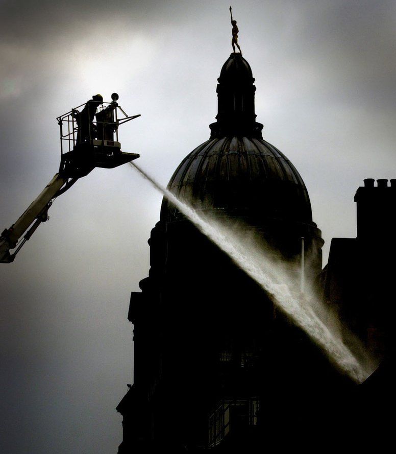 The dome of University of Edinburgh's Old College in the background as firefighters continue to dampen the Cowgate fire the day after the blaze broke out. The Old College escaped damage but the university's School of Informatics was badly damaged with thousands of books destroyed