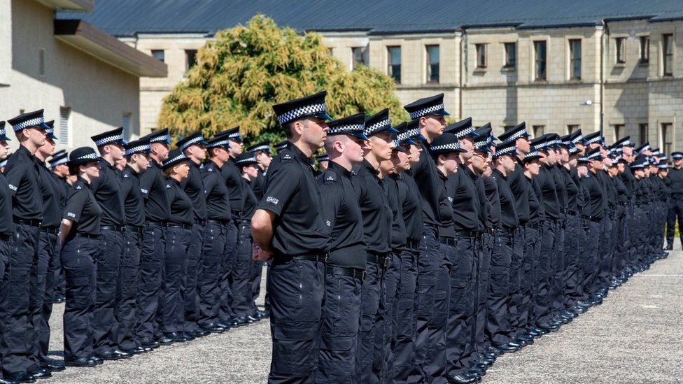 New police officers taking the oath of office at the force's headquarters in July