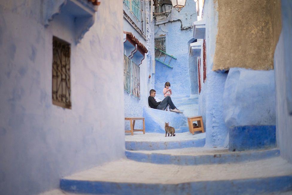 Children sit outside their home in the town of Chefchaouen in northwest Morocco. The town famous for its blue painted buildings was founded as a military outpost in 1471 shortly before the Spanish Reconquista of Granada, and its population grew quickly with Muslim and Jewish immigrants fleeing from Spain.