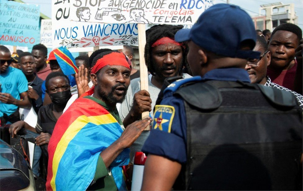 A Congolese resident talks to a policeman as they protest the deployment of a regional force which they see as ineffective in tackling the resurgent rebel group in North Kivu following renewed tensions around Goma in the North Kivu province of the Democratic Republic of Congo December 1, 2022.