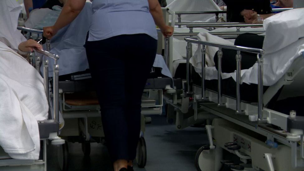 Staff moving trolleys in emergency department
