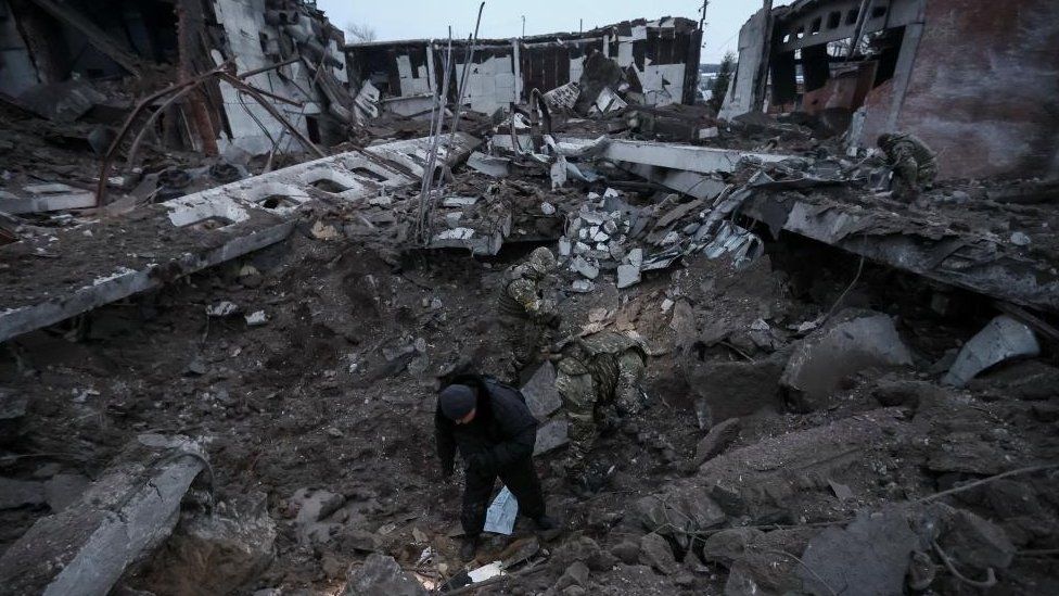 Police and investigators inspect a crater at a site of an industrial area destroyed by a Russian missile strike, amid Russia's attack on Ukraine, in Kharkiv, Ukraine December 15, 2022