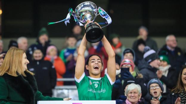 Sarsfields captain Niamh McGrath holds the Bill & Agnes Carroll Cup aloft after victory over Loughgiel