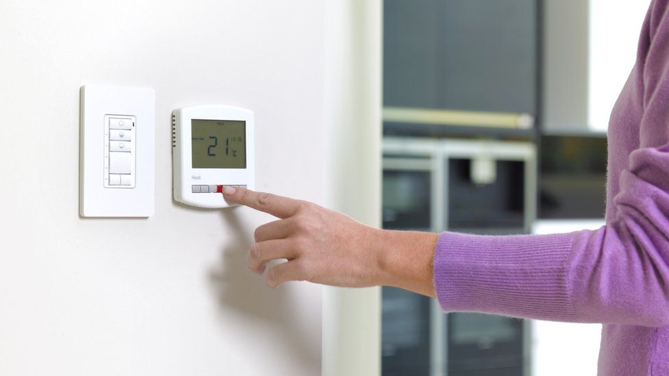 woman turning heating on