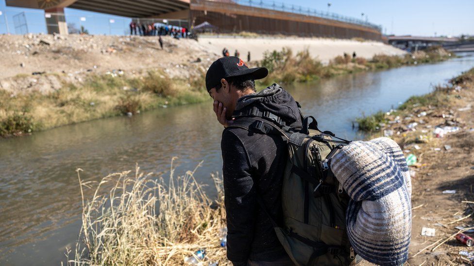 An immigrant prepares to cross the Rio Grande into El Paso, Texas on December 19, 2022