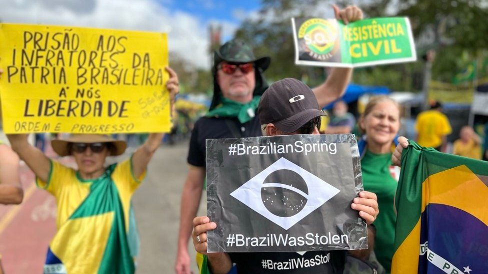 Protesters hold up signs in SĂ£o Paulo