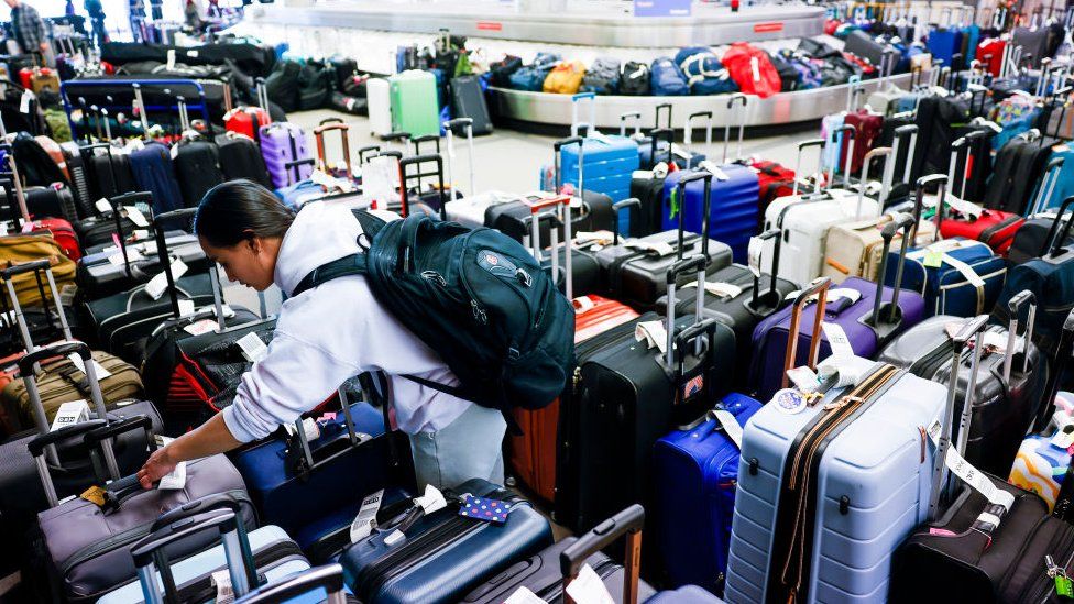 A person searches for luggage at a baggage holding area for Southwest Airlines at Denver International Airport