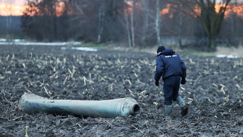 An investigator walks near a fragment of a munition, what Belarus' defence ministry said was part of a Ukrainian S-300 missile downed by Belarusian air defences near the village of Harbacha in the Grodno region, Belarus, December 29, 2022