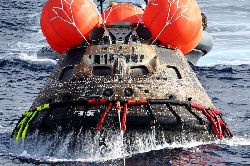 NASA's Orion capsule is drawn to the well deck of the USS Portland after it splashed down December 11 in the Pacific Ocean off the coast of Baja California, Mexico. following a successful uncrewed Artemis I moon mission. Pool photo by Mario Tama/UPI | <a href="/News_Photos/lp/705f43759dba87e7e6825eba5fecc85e/" target="_blank">License Photo</a>