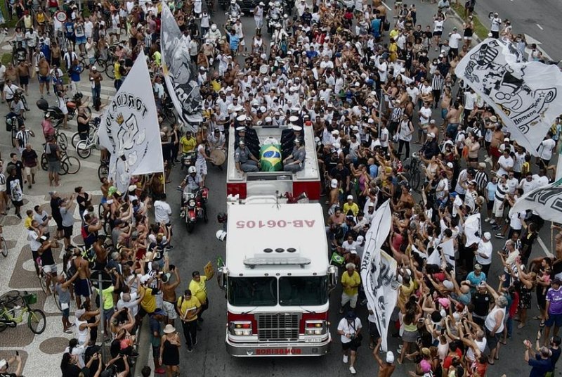 A fire engine carrying the coffin with Pelè leads a funeral procession in Santos, Brazil. Photo by Antonio Lacerda/EPA-EFE