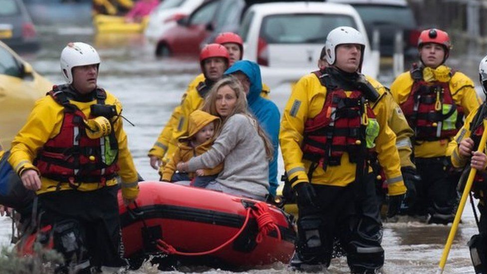 A family is rescued from floodwater in Nantgarw by boat