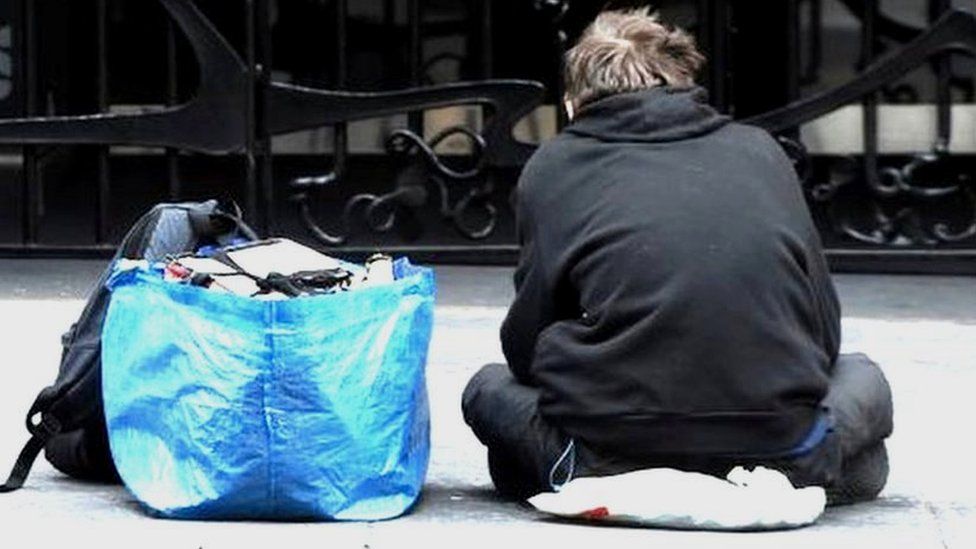 A homeless person sits in a Glasgow city centre street on March 27, 2020