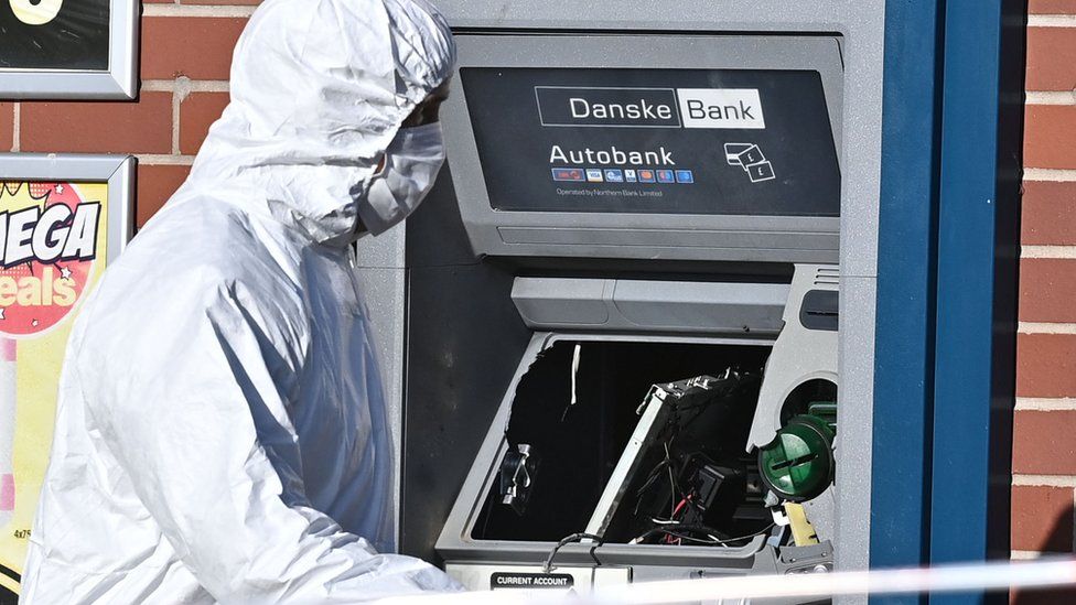 A forensic officer examines the cash machine that was damaged in the explosion