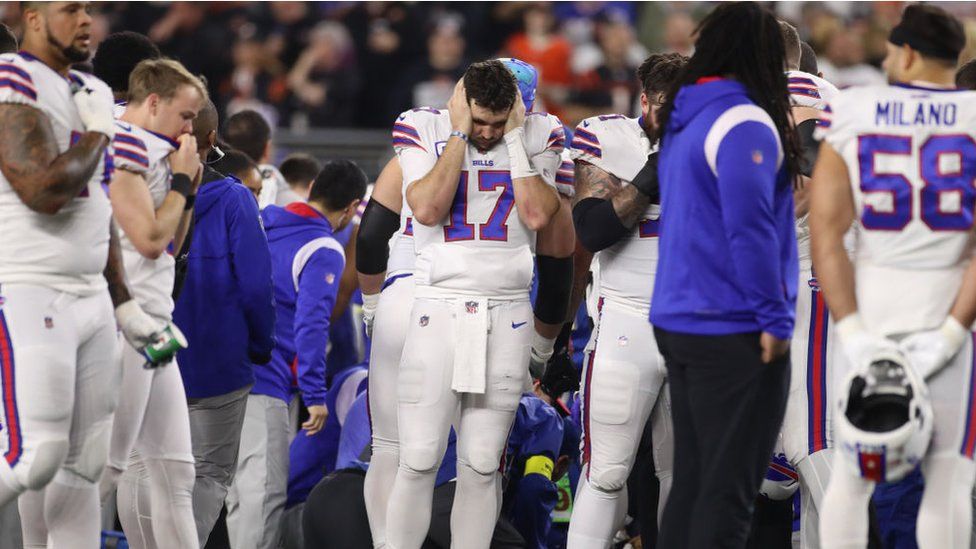 Buffalo Bills players react as medical officials treat their teammate Damar Hamlin