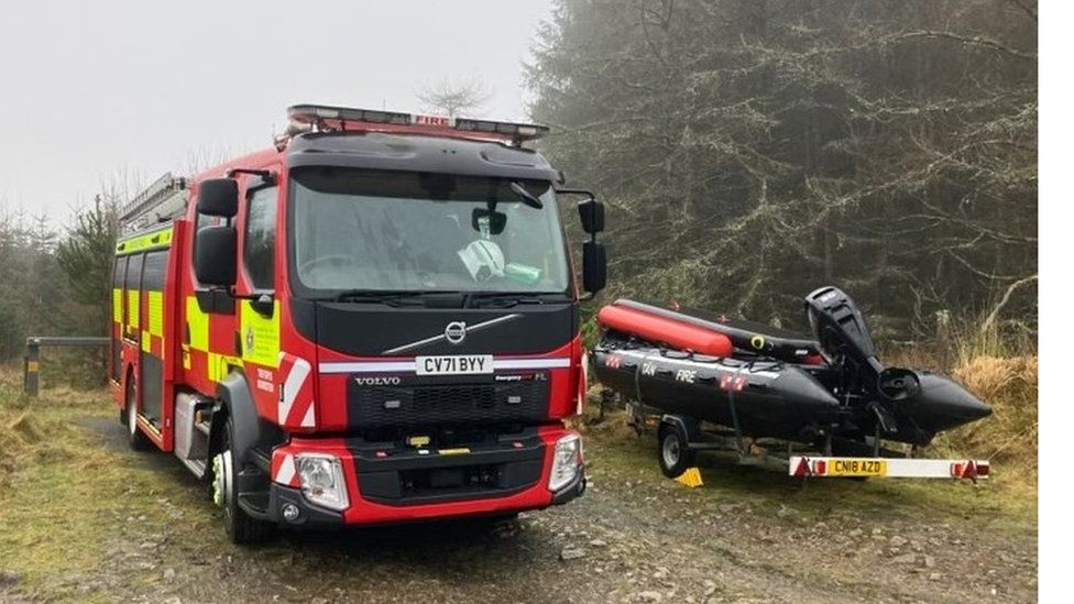 A fire engine next to a rescue boat