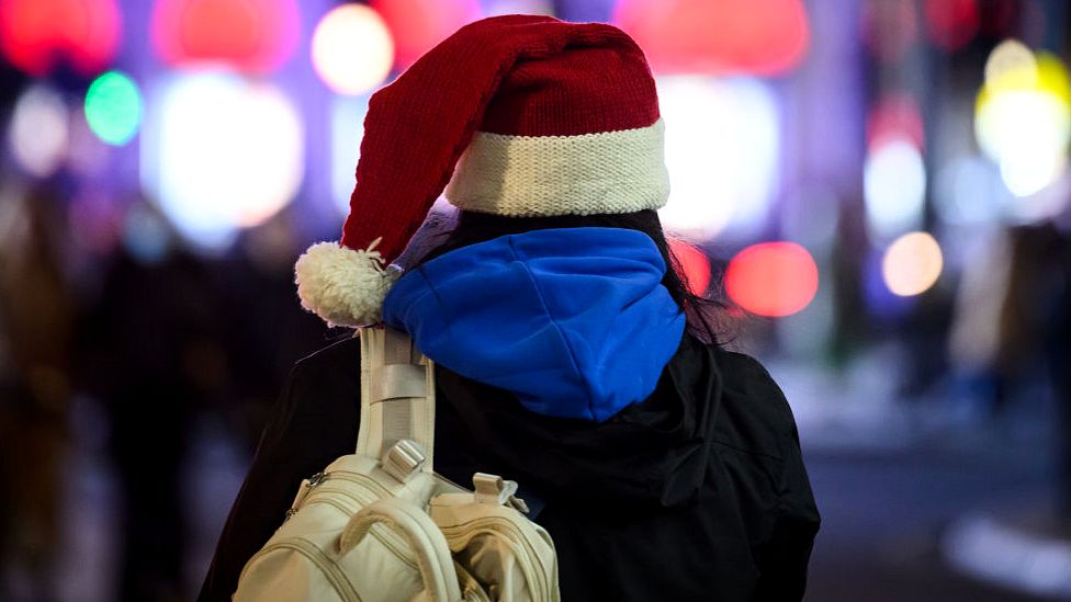 Woman in Santa hat Christmas shopping