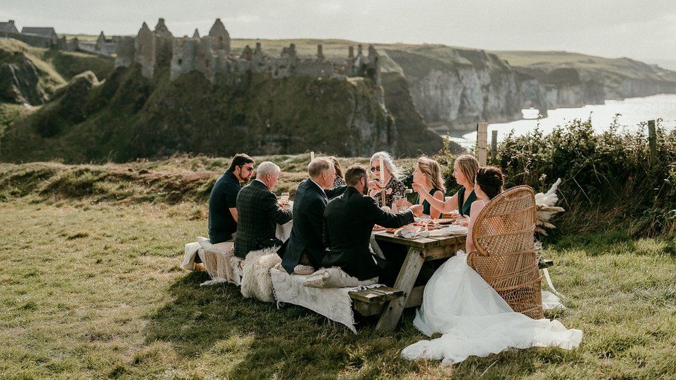 Jamie and Corey with guest enjoying a picnic overlooking Dunluce Castle