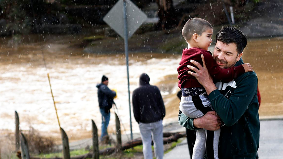 Man carries son away from floodwaters in Gilroy, California