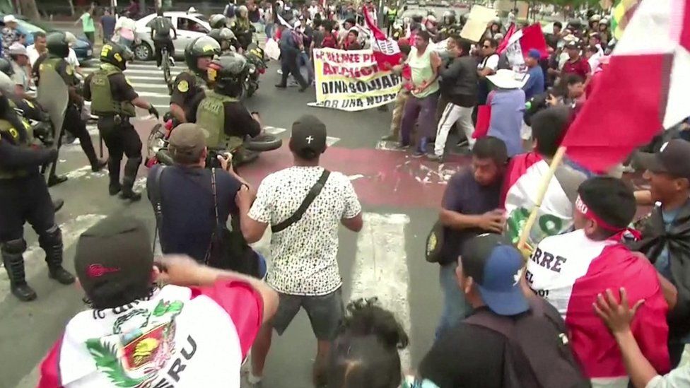 Crowds of protesters confront a number of police officers in Peru's capital, Lima