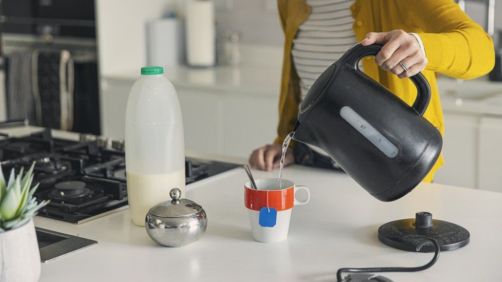 Woman pouring water from kettle