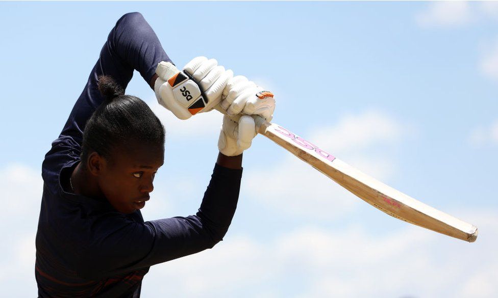 Oluhle Siyo strikes the ball with her bat.