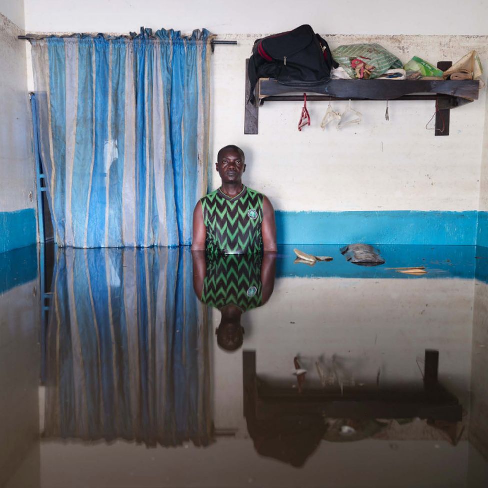 Prince Ogiasa Lume standing in flood water in his home in Ogbia Municipality, Bayelsa State, Nigeria - November 2022