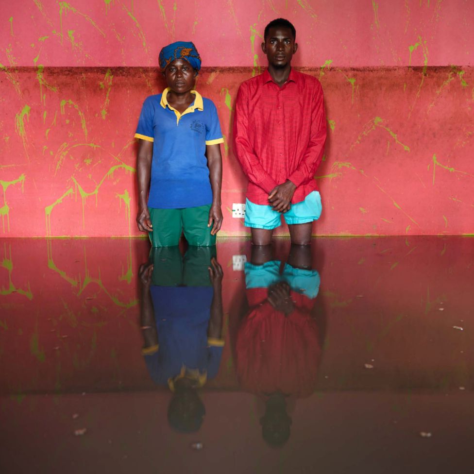 Edigiraru Donald and Iruaro Robert standing in flood water in their home in Ogbia Municipality, Bayelsa State, Nigeria - November 2022