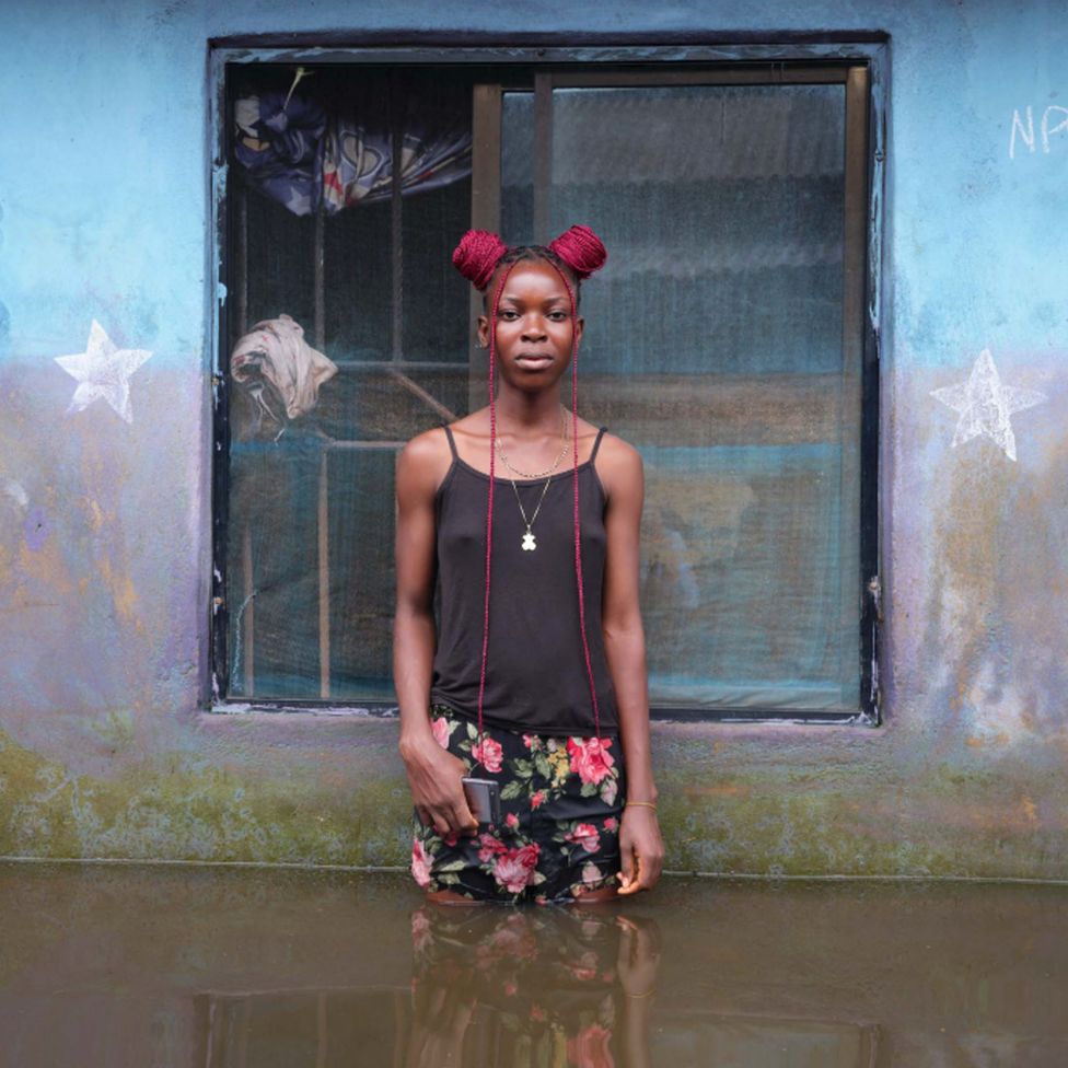 Winner Odums standing in flood water outside her home in Ogbia Municipality, Bayelsa State, Nigeria - November 2022